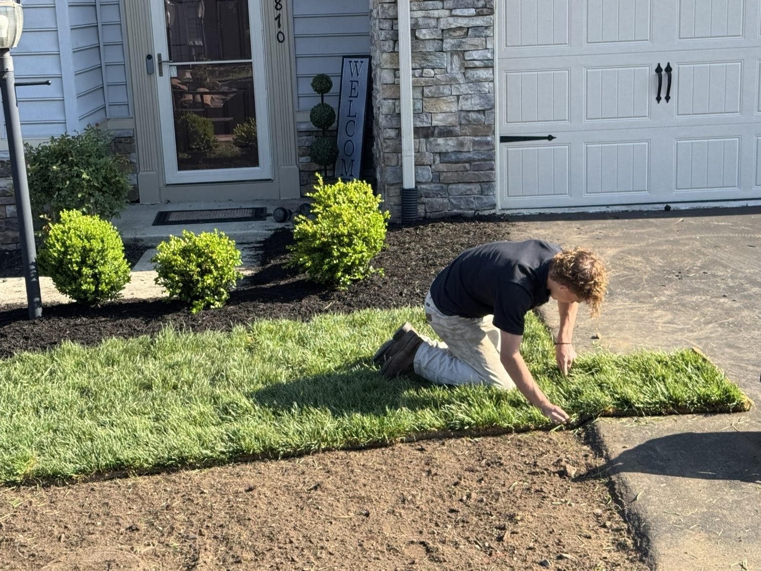 LivingStone Landscaping owner installing fresh sod